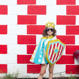 Child Superhero Costume in Action Blue Stripe Cape against wall