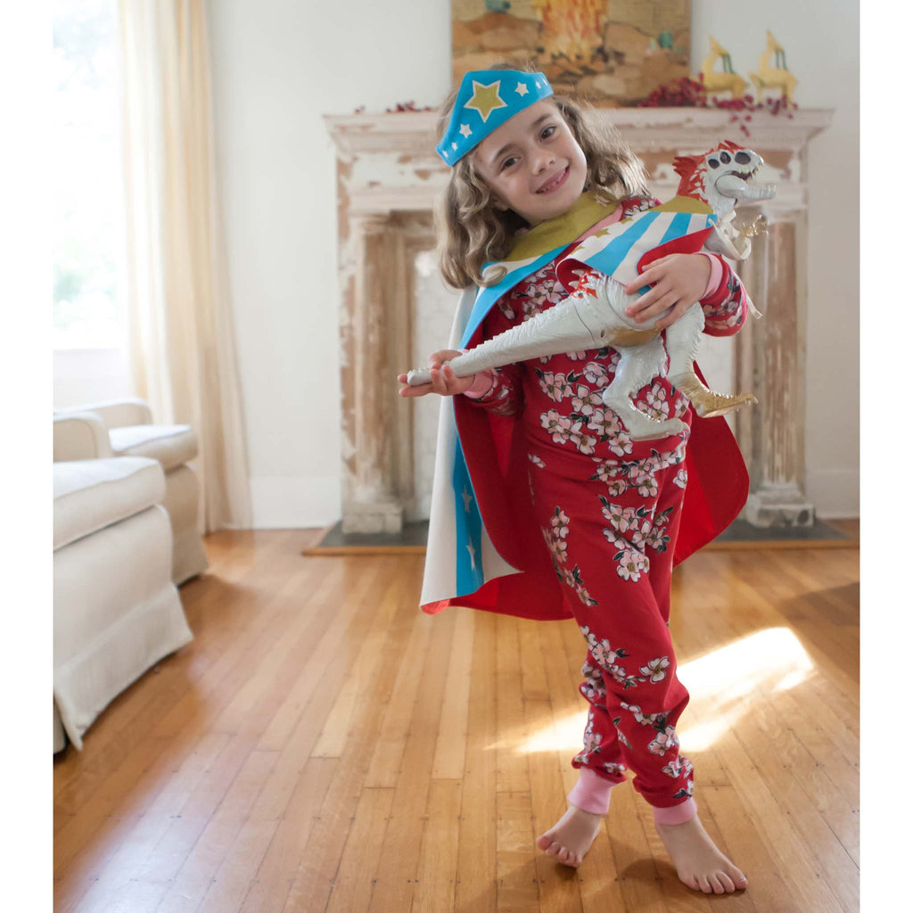 child wearing pajamas superhero costume holding toy
